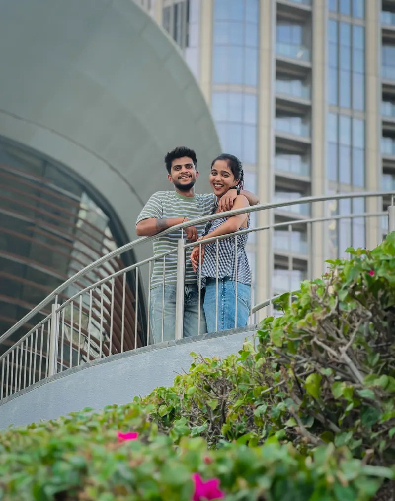 Jishnu and Alka leaning on a railing, smiling