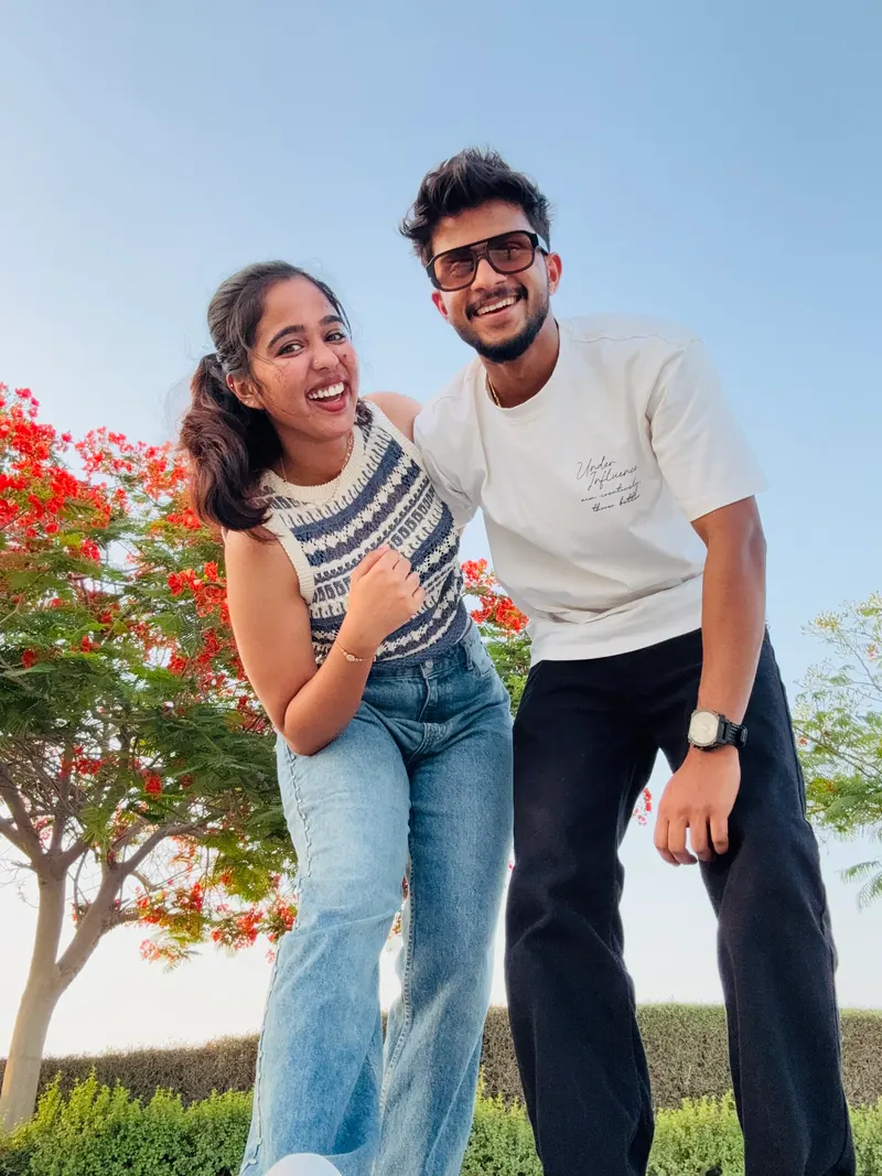 Alka and Jishnu laughing together under a flowering tree
